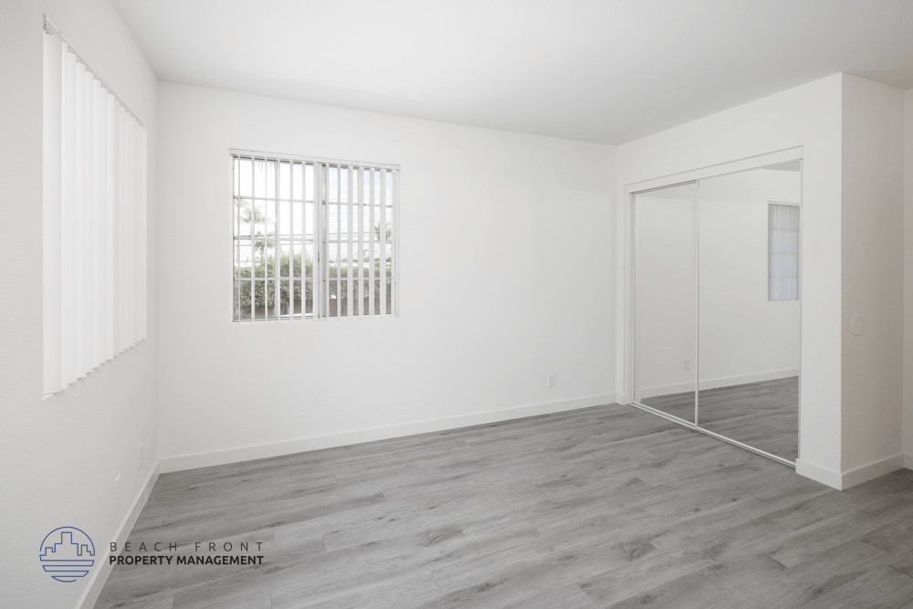 A room with a window and a door is empty and waiting to be furnished.